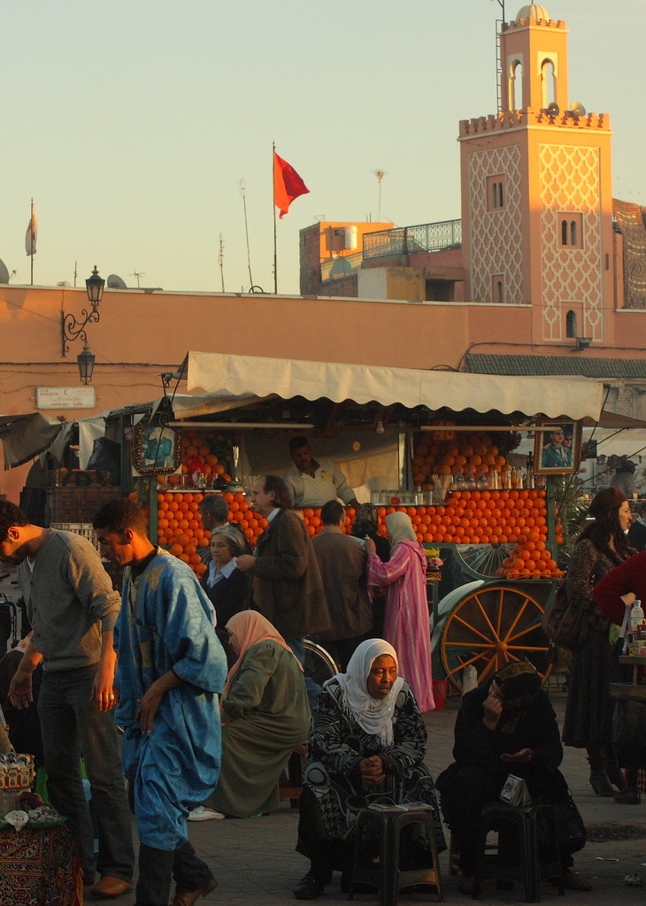 Busy souk market alley in Marrakech with stalls of lanterns and textiles